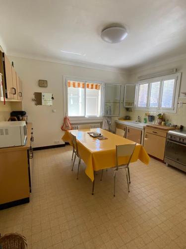 une cuisine avec une table jaune et des chaises dans l'établissement Appartement dans Villa à Antibes avec Vue Mer, à Antibes