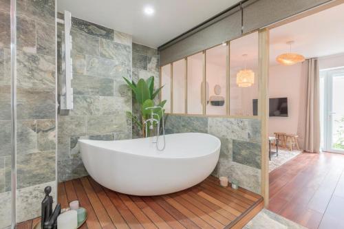 a bathroom with a white tub in a room at Le Grand Bastion, Luxury T2 - avec climatisation in Lescar