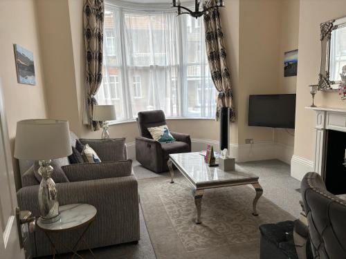 a living room with two chairs and a tv at Moat Stays Victorian, Sea View! in Kent