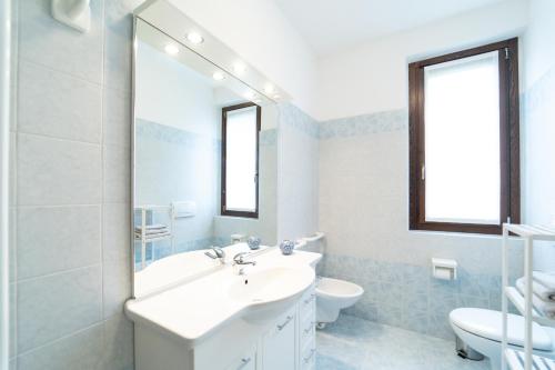 a bathroom with a sink and a toilet and a mirror at Como 5 min - House with Terrace and Parking - Wifi in San Fermo della Battaglia