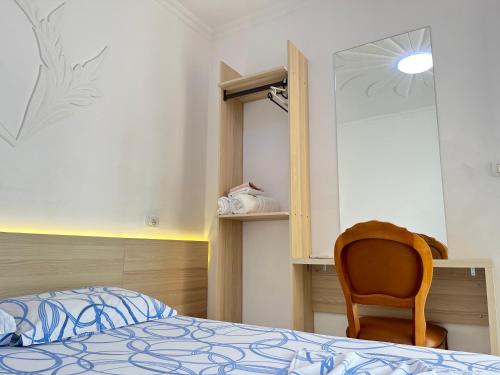 a bedroom with a bed and a chair at Villa Kasa in Durrës