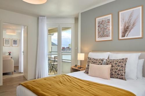 une chambre avec un grand lit et un balcon dans l'établissement Zenitude Hôtel-Résidences Saumur, à Saumur