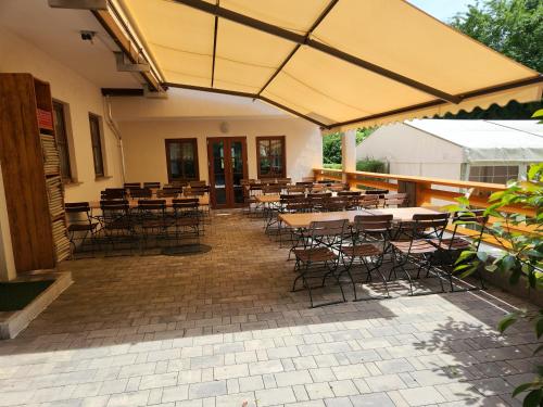 a patio with tables and chairs in a building at Landgasthof Hummel in Ebensfeld