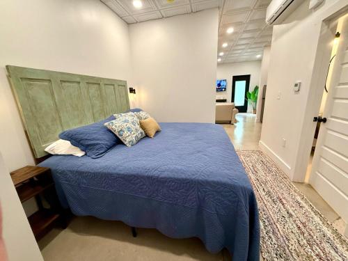 a bedroom with a bed with blue sheets and pillows at Cozy Cure Apartment in Downtown and Historic Pilot Mountain in Pilot Mountain