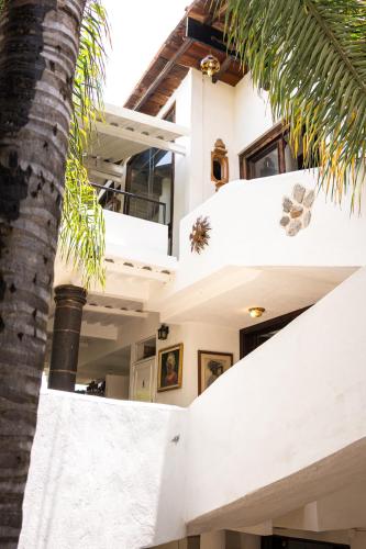 a house with white walls and a palm tree at SOLACHE INN in Zitácuaro