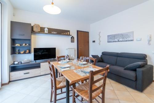 a living room with a table and a couch at Como 5 min - House with Terrace and Parking - Wifi in San Fermo della Battaglia