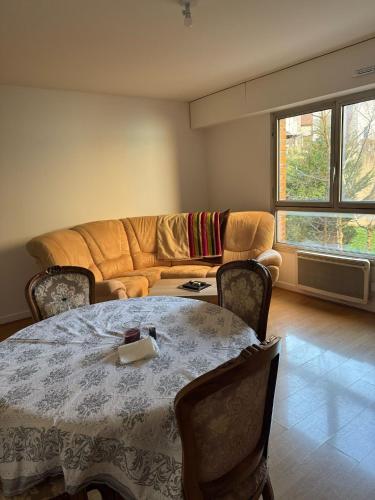 un salon avec une table et un canapé dans l'établissement Spacieux 3 pièces Balcon Rive gauche de la Seine, à Issy-les-Moulineaux