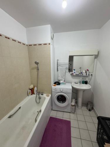 une salle de bain avec une machine à laver et un lavabo dans l'établissement Spacieux 3 pièces Balcon Rive gauche de la Seine, à Issy-les-Moulineaux