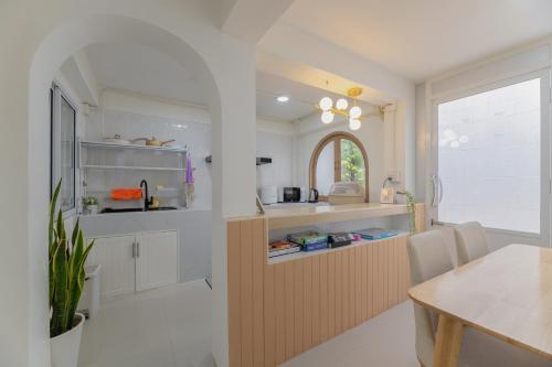 a kitchen with a counter and a dining room at Monoji House - บ้านพักในสันติธรรมพร้อมไวไฟ in Chiang Mai