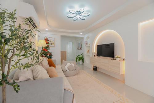 a living room with a tv and a couch at Monoji House - บ้านพักในสันติธรรมพร้อมไวไฟ in Chiang Mai