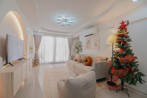 a living room with a christmas tree and a couch at Monoji House - บ้านพักในสันติธรรมพร้อมไวไฟ in Chiang Mai