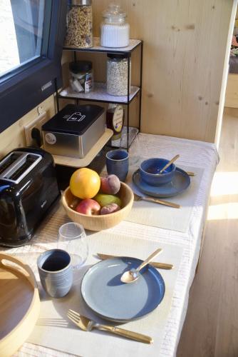 a table with blue plates and a bowl of fruit at La Tiny House des Vignes du Château de Vauclaire in Meyrargues