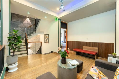 a living room with a red bench and a staircase at Square Villa Hoi An in Hoi An