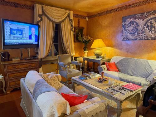 un salon avec un canapé et une télévision dans l'établissement Appartement de luxe au cœur de Saint-Tropez, à Saint-Tropez