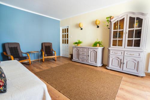 1 dormitorio con 1 cama, armario y sillas en Apartament Danusia, en Kołobrzeg