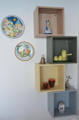 a shelf with bowls and plates on a wall at Capo Cervo - Rocce di Capo Mimosa in Cervo