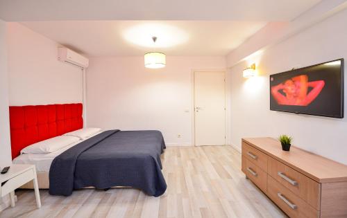 a bedroom with a bed and a flat screen tv at Royal Accommodation in Bucharest
