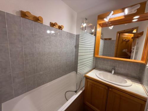 une salle de bain avec un lavabo et un miroir dans l'établissement Les Saisies: Studio cabine 5 pers avec balcon, TV et casier à skis - FR-1-293-130, aux Saisies