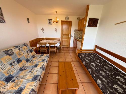 un salon avec un canapé et une table dans l'établissement Les Saisies: Studio cabine 5 pers avec balcon, TV et casier à skis - FR-1-293-130, aux Saisies