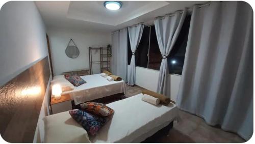 une chambre avec deux lits et une fenêtre dans l'établissement Casa Pé na Areia Praia de Piratininga, à Niterói