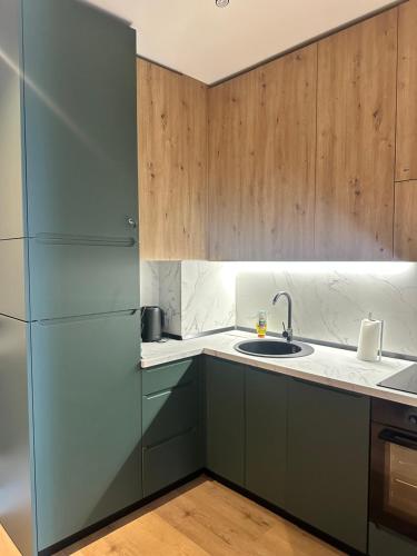 a kitchen with a sink and a refrigerator at Alpine Oasis - Silver Mountain in Poiana Brasov