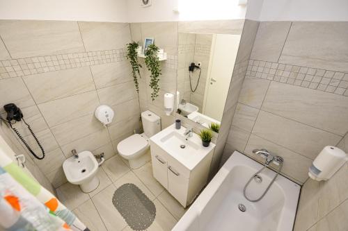 a bathroom with a toilet and a sink and a tub at Royal Accommodation in Bucharest
