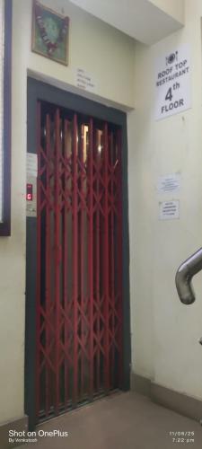 a red door in a building with a sign on the wall at Hotel Landmark in Port Blair