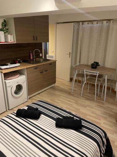 une chambre avec un lit et une cuisine avec une table dans l'établissement Studio 23m2 5mn gare 3 couchages, à Trouville-sur-Mer