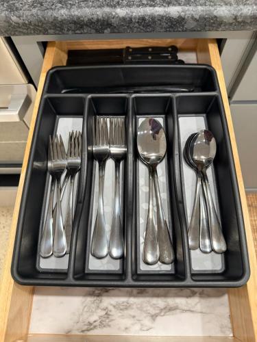 a tray of silver utensils in a drawer at Restful Remedy in Downtown & Historic Pilot Mountain Apartment in Pilot Mountain