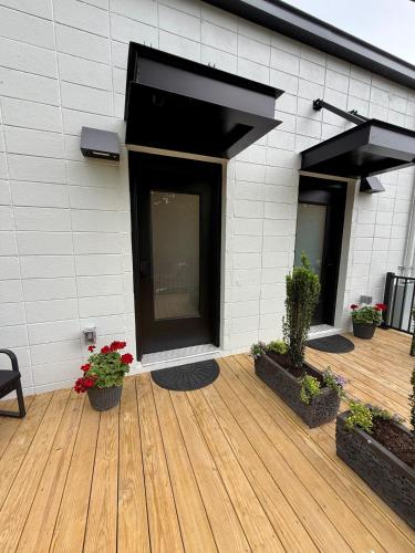 a building with a wooden deck with potted plants at Restful Remedy in Downtown & Historic Pilot Mountain Apartment in Pilot Mountain
