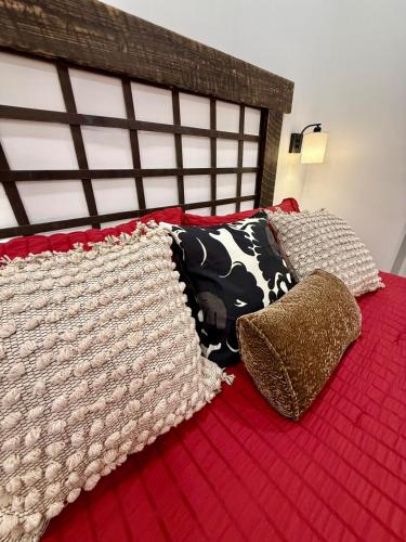 a bed with a red blanket and two pillows on it at Restful Remedy in Downtown & Historic Pilot Mountain Apartment in Pilot Mountain