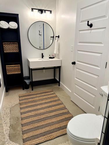 a bathroom with a sink and a mirror and a toilet at Restful Remedy in Downtown & Historic Pilot Mountain Apartment in Pilot Mountain