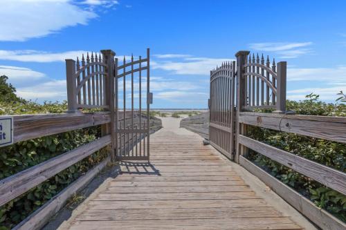 a wooden pathway with a gate on a boardwalk at Sail Inn SaintSimons-ground unit beach access pool in East End