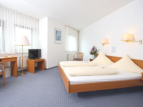 a hotel room with two beds and a television at City Hotel Mark Michelstadt in Michelstadt