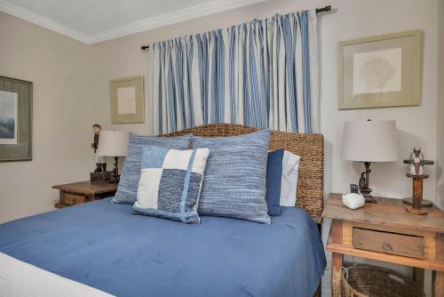a bedroom with a bed with blue sheets and pillows at Sail Inn SaintSimons-ground unit beach access pool in East End