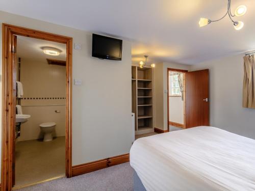 a bedroom with a bed and a bathroom with a toilet at 3 Bed in Crediton WAIEC in Zeal Monachorum
