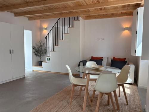 a dining room with a table and chairs and a staircase at Casas do Mercado, 5 in Montemor-o-Novo