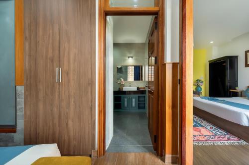 a room with a bedroom with a bed and a bathroom at Square Villa Hoi An in Hoi An
