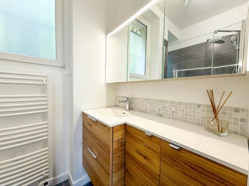 une salle de bain avec un lavabo et un miroir dans l'établissement Urban Flat 169 - Pretty Flat Bercy Coriolis, à Paris