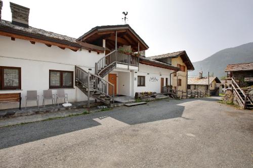 a building with a balcony and stairs on it at Agriturismo Soleil Levant Torgnon in Torgnon