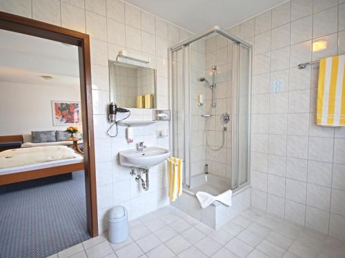 ein Bad mit einer Dusche und einem Waschbecken in der Unterkunft City Hotel Mark Michelstadt in Michelstadt