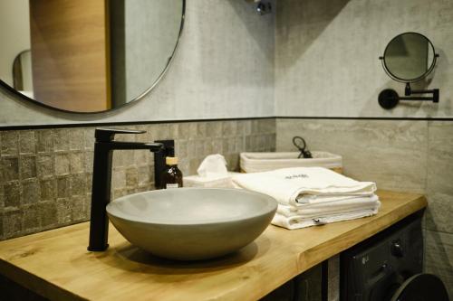 a bathroom with a bowl sink and a mirror at IL FOCOLARE Premium Suites in Avilés