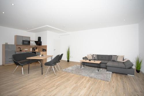 a living room with a couch and a table and chairs at Klosterhof Aue W 14 in Bad Zwischenahn