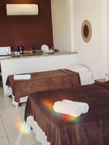 a room with two beds with a rainbow on the floor at Caiçara Flats in Cabo Frio