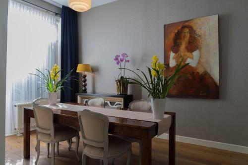 a dining room table with chairs and a painting on the wall at B&B House No 7 in Amsterdam