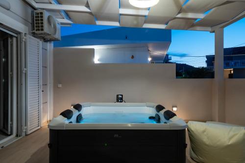 a large bath tub in a room with a window at Villy Suites in Argasi