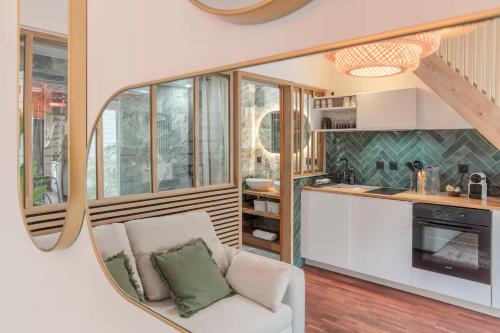 a kitchen and living room with a couch and a mirror at Le Grand Bastion, Luxury T2 - avec climatisation in Lescar