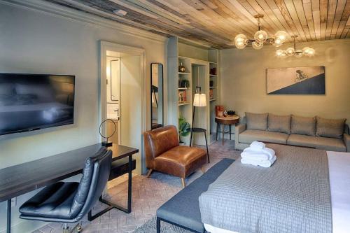 una camera da letto con un letto, un divano e una TV di 1st floor King Suite Downtown Boutique Hotel a Savannah