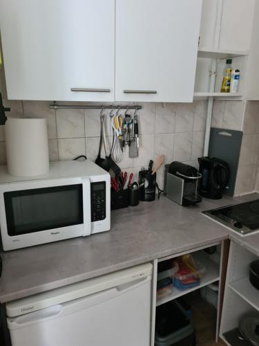a kitchen with a microwave on a counter at Appartement calme in Clichy