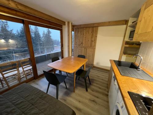 a kitchen and dining room with a table and chairs at Très bel appartement exposition sud classé 3 étoiles in Chamrousse